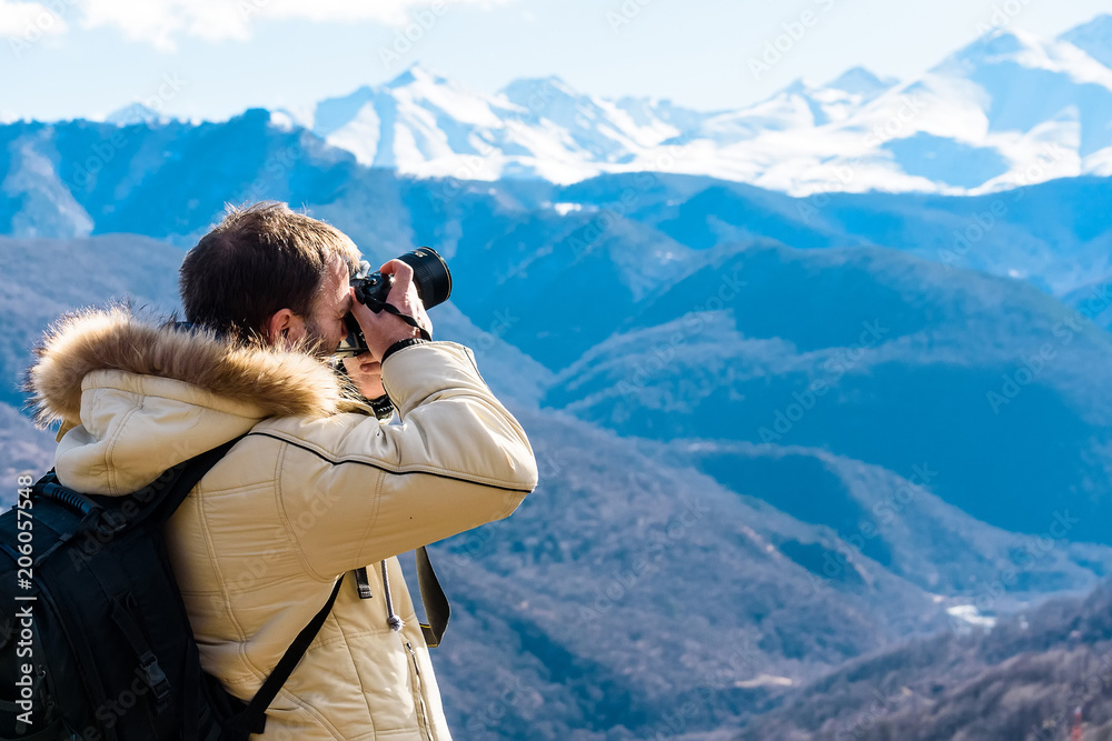 Male photographer in winter mountrains back view Male photographer in winter mountrains back view