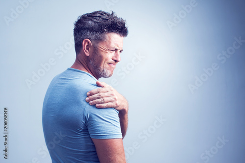 People, healthcare and problem concept - unhappy man suffering from neck or shoulder pain at home photo