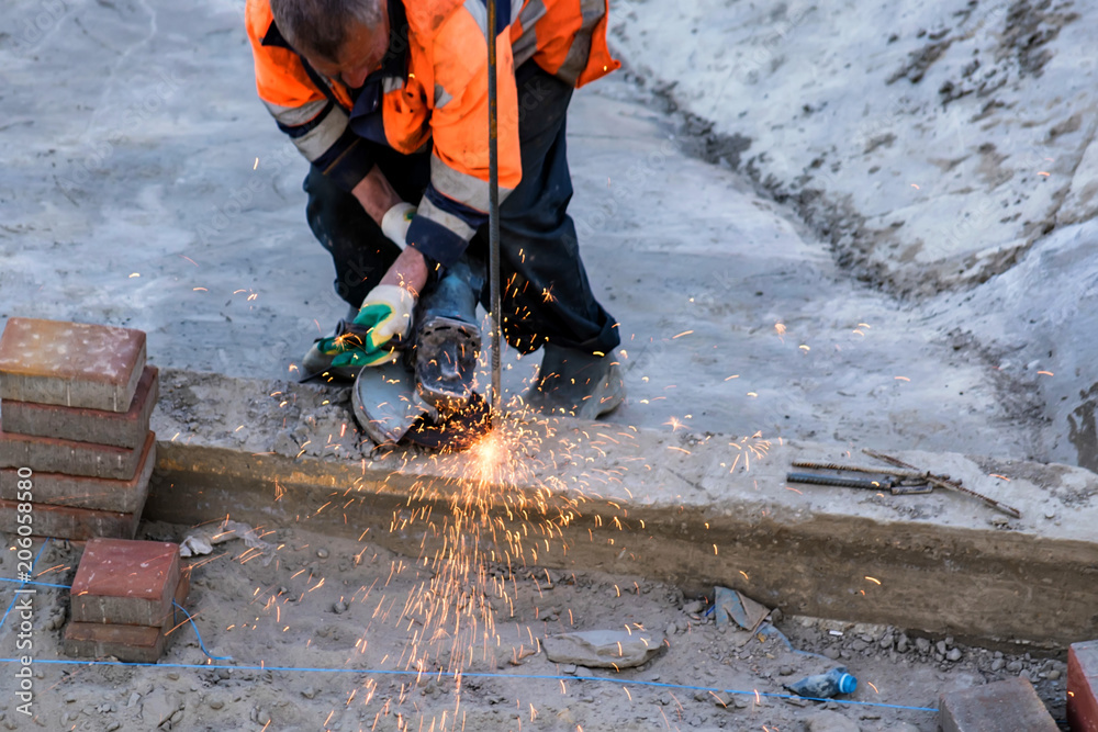 Road worker uses circular saw close Road worker uses circular saw close