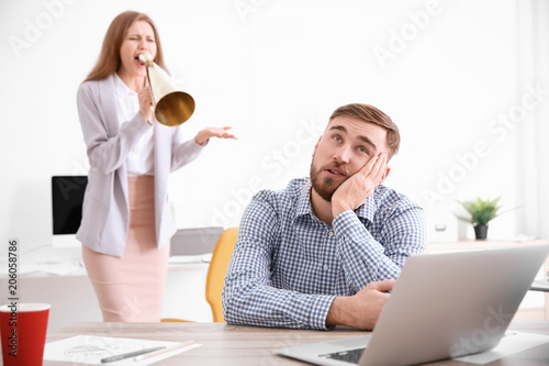 Angry boss with megaphone s...