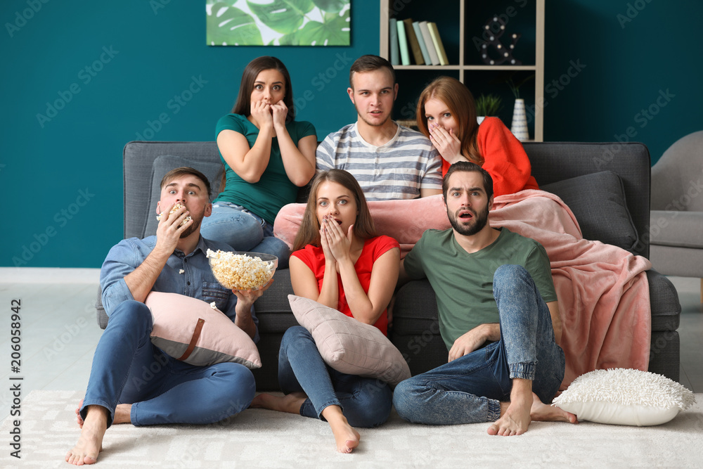 Naklejka premium Young people watching TV at home