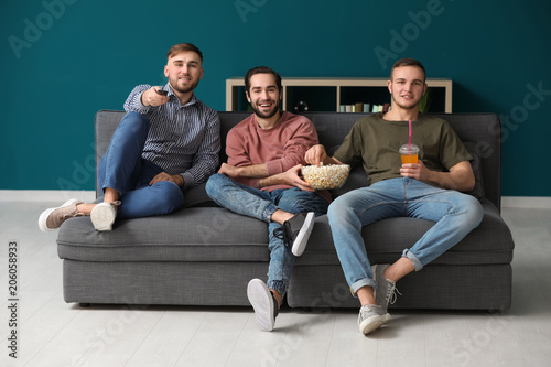 Young men watching TV at home