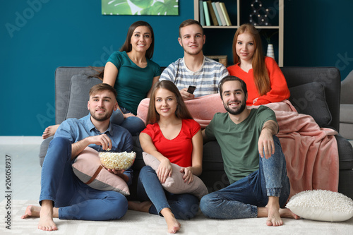 Young people watching TV at...