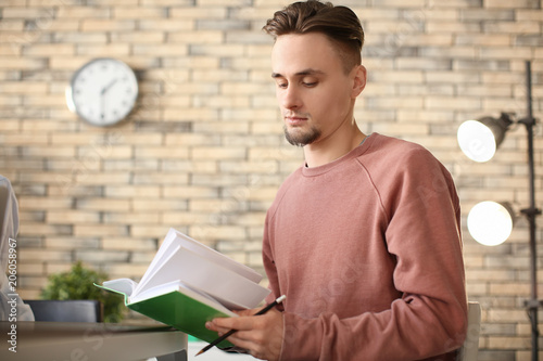 Male student reading book i...