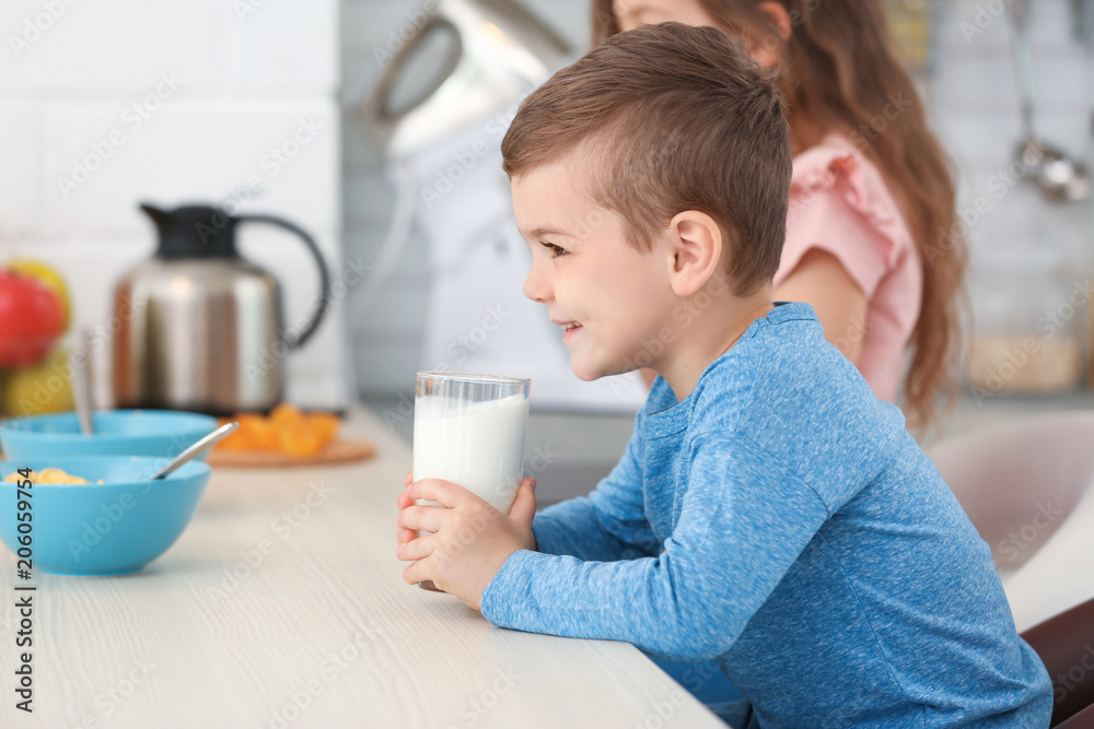 Cute little boy drinking milk in kitchen Cute little boy drinking milk in kitchen
