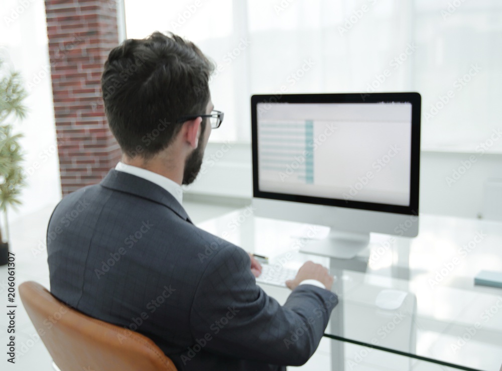 businessman sitting at his desk and making a financial report.
