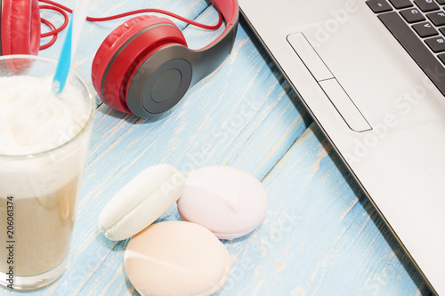 open laptop with white Cup of coffee, marshmallows and red headphones. photo