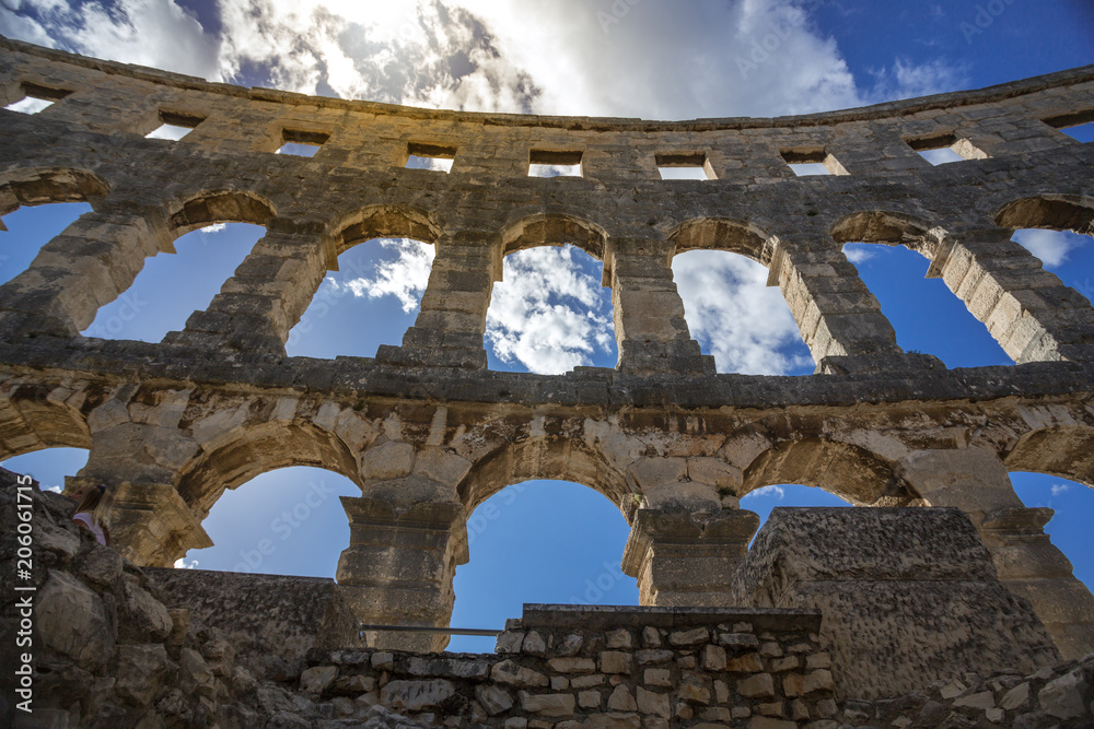 Glimpse of the Pula Arena, a symbol of the Croatian city in Istria. View of the arches and walls surrounding the Pula Arena, a tourist attraction which attracts tourists from all over the world. Glimpse of the Pula Arena, a symbol of the Croatian city in Istria. View of the arches and walls surrounding the Pula Arena, a tourist attraction which attracts tourists from all over the world.