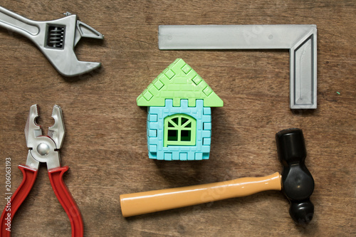 Home model object with toy equipment tool on wood background (Concept for home repair or fix) photo