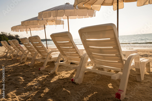 Empty beachchairs under white umbrellas on summer beach. photo