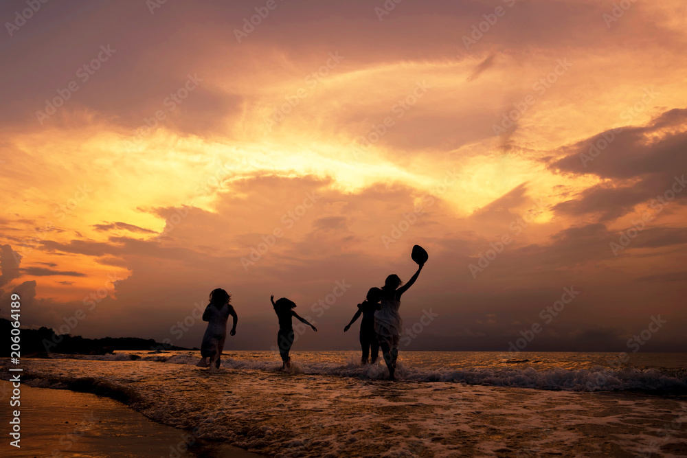 Fototapeta premium Sylwetka szczęśliwy dziewcząt razem na plaży o zachodzie słońca. Koncepcja wakacji letnich. Dźwięk kinowy z ziarnem.