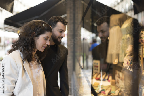 Woman and husband looking chothes store showcase