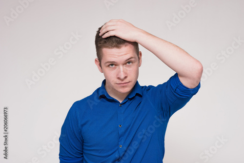 Portrait of a beautiful dissatisfied young man on a white background. photo