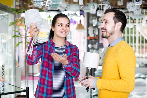 man and girl in lighter shop discussing purchase of bedside lamp for house