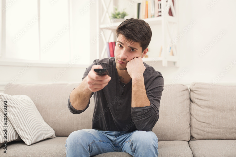 Young boring man watching television at home Young boring man watching television at home