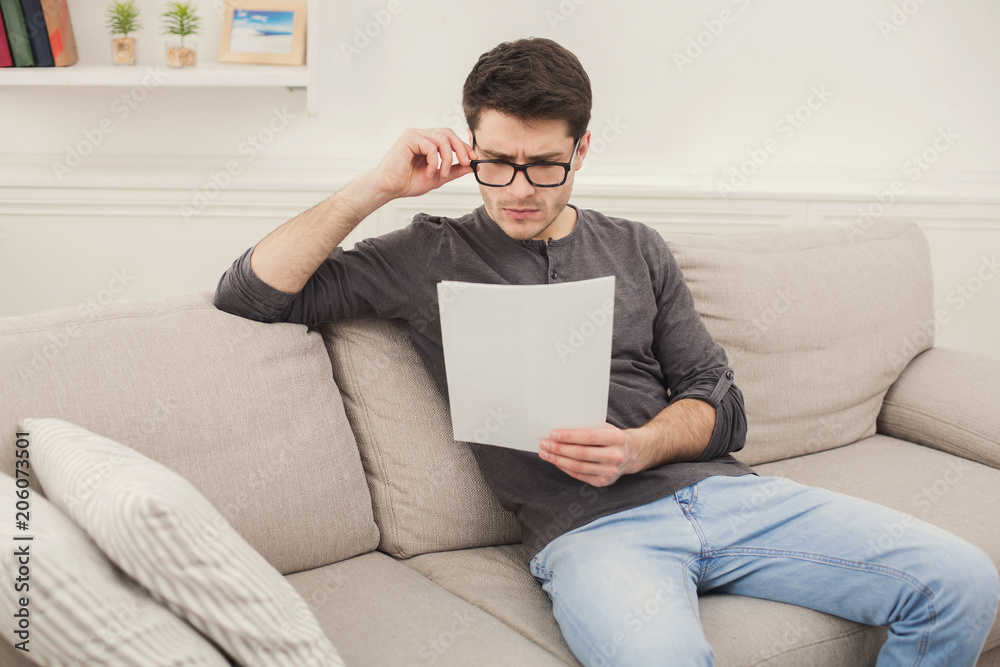 Young tired businessman reading report at home Young tired businessman reading report at home