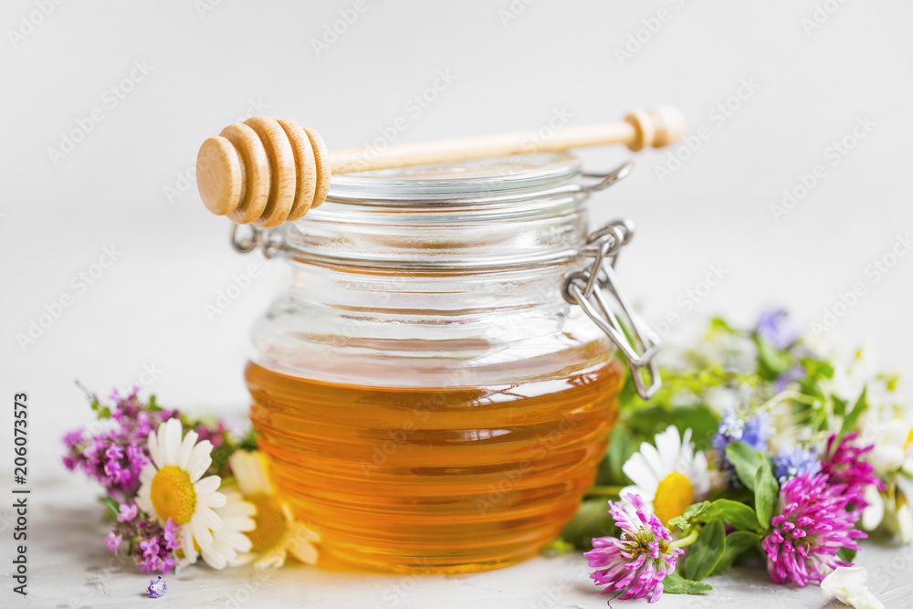 Raw organic honey jar with flowers Raw organic honey jar with flowers