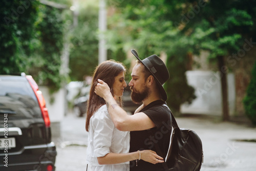 Pretty beautiful couple. Hold each other hands in old city. People wearing in denim jeans and transperency skirt. Man and woman in love. Concept street style. Emotion together forever. photo