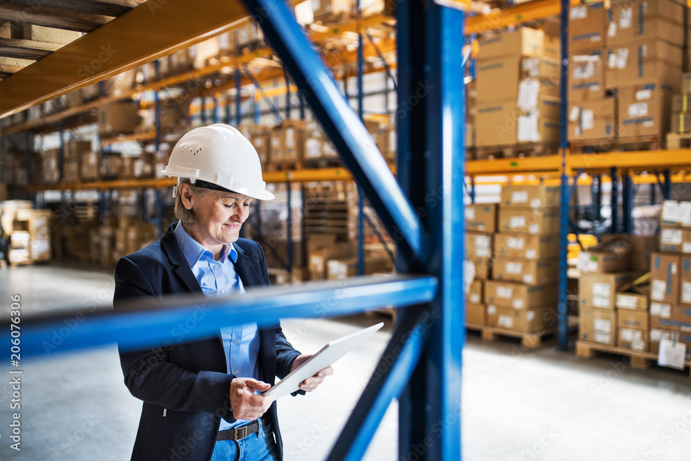 Senior woman warehouse manager or supervisor with tablet, working. Senior woman warehouse manager or supervisor with tablet, working.