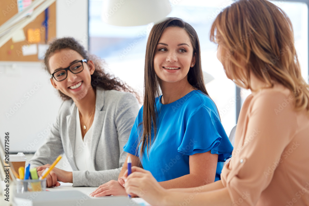 business, teamwork and people concept - female team or businesswomen talking at office business, teamwork and people concept - female team or businesswomen talking at office