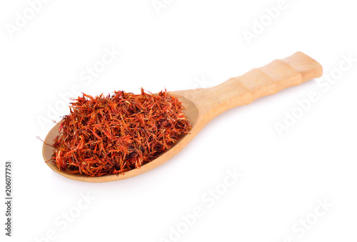 dried safflower in wooden spoon and on white background
