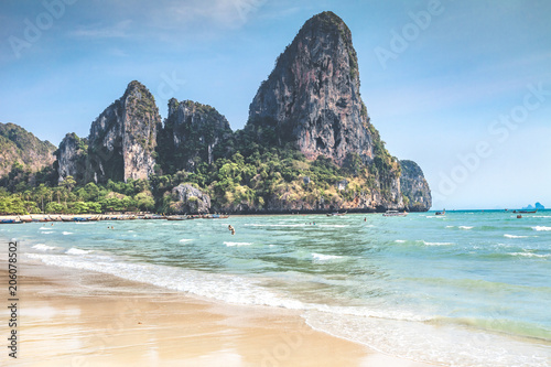 Spectacular view of the shore of the crystal clear warm ocean next to the exotic tropical island in the kingdom of Thailand. Amazing limestone cliffs background. Ideal beach for the paradise rest.
