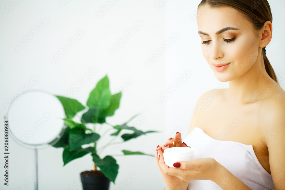 Beautiful model applying cosmetic cream treatmen on her face Beautiful model applying cosmetic cream treatmen on her face