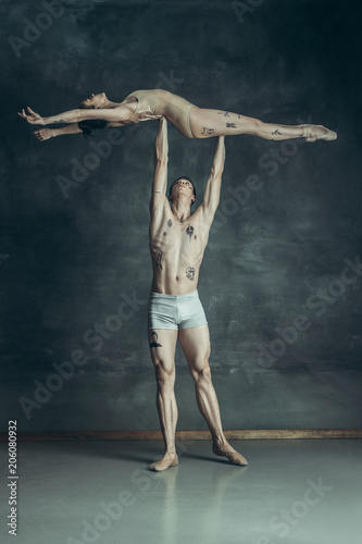 The young modern ballet dancers posing on gray studio background