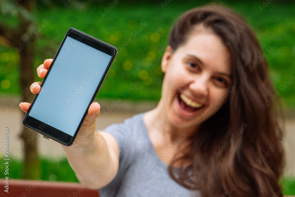 young adult woman showing phone with white screen. copy space