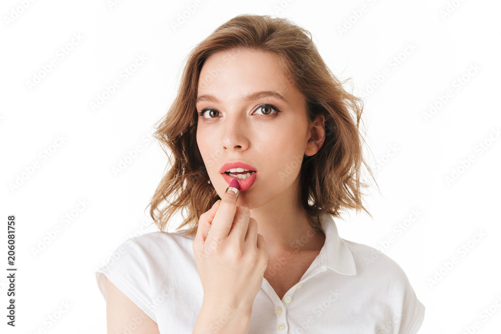 Portrait of beautiful woman dreamily looking in camera while holding lipstick in hand on white background isolated Portrait of beautiful woman dreamily looking in camera while holding lipstick in hand on white background isolated