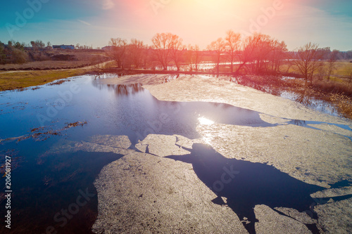 Aerial view of a river with floating ice in early spring. Rural landscape. Wild nature