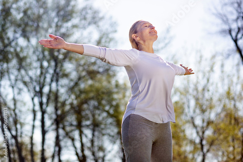 Fototapeta Naklejka Na Ścianę i Meble -  Being outdoors. Happy peaceful woman breathing fresh air while enjoying being outdoors