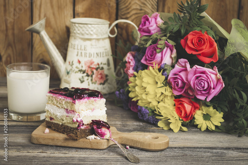 cherry jelly cake and beautiful bouquet of flowers on an old wooden background