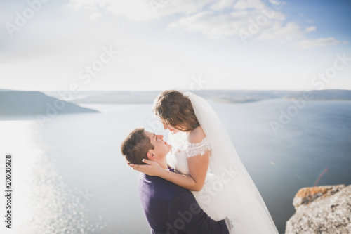 Happy wedding couple staying over beautiful landscape © olegparylyak