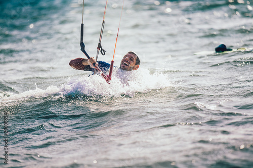 Kitesurfing Kiteboarding action photos man among waves quickly goes