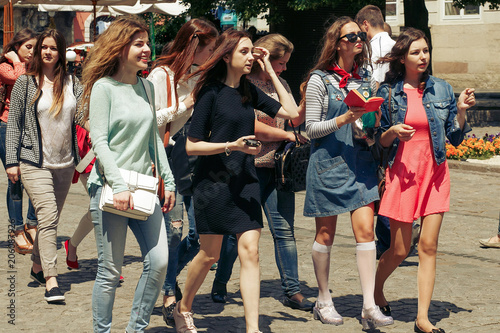many young happy women walking talking on background of old european city street, stylish hipster girls having fun, moments of happiness, friendship concept