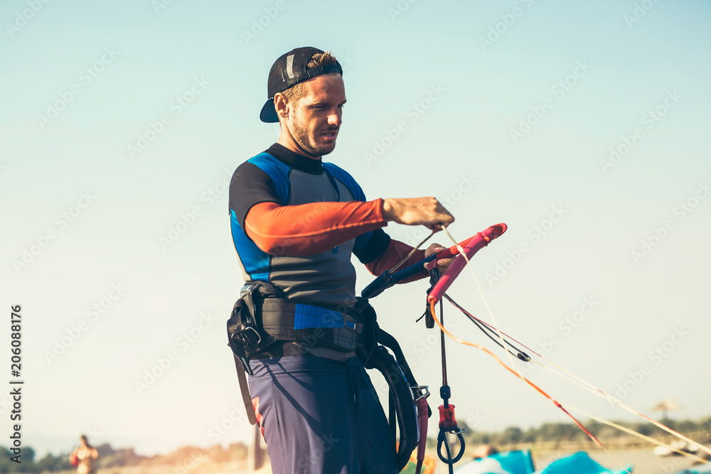Man sufrers in wetsuits with kite equipment for surfing. Man sufrers in wetsuits with kite equipment for surfing.