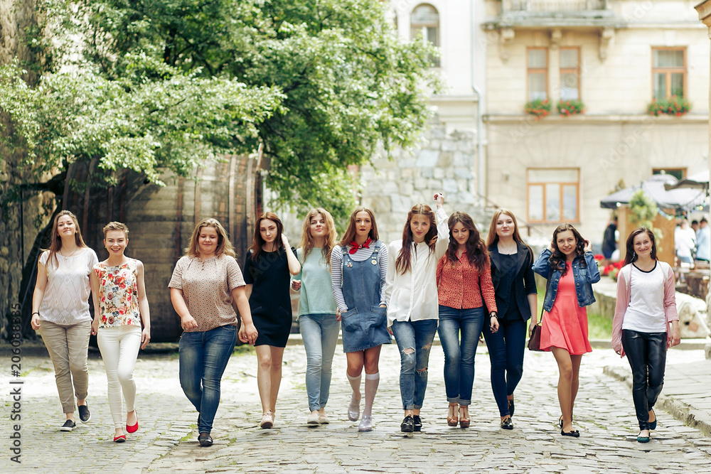 Group of many happy women walking having fun on background of old european city street, celebrating friendship concept, moments of happiness