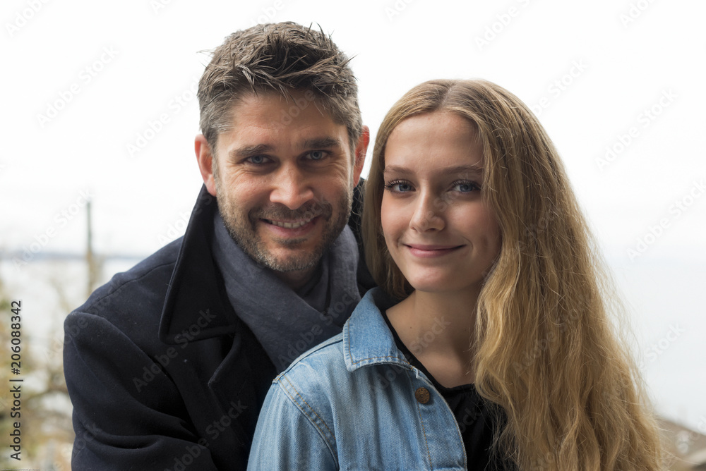 Father and teenage daughter are posing for portrait shots outside