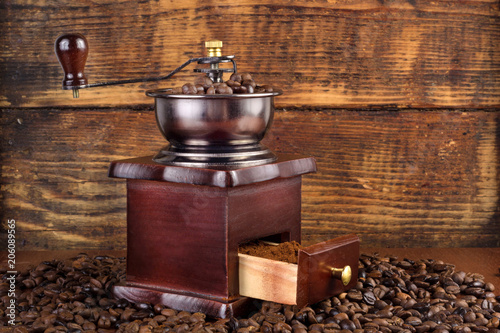 Traditional wooden coffee mill grinder with roasted coffee beans and wooden background. Retro and Vintage Food and drink concept