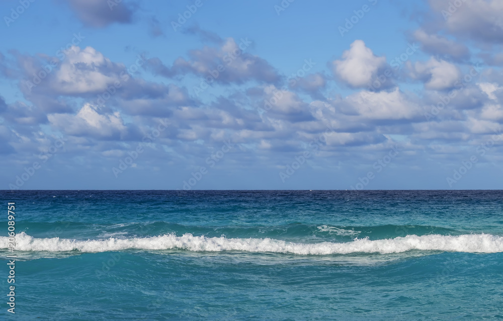 line of the ocean, small waves, horizon, endless distance, against the sky covered with clouds, Cuba