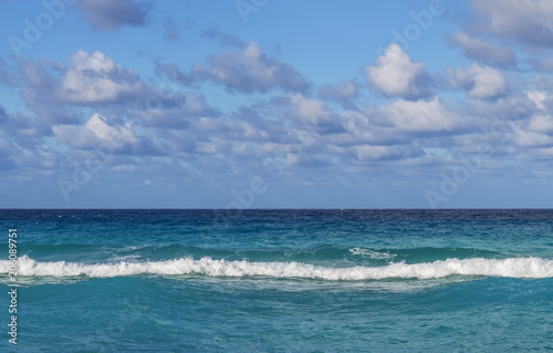 line of the ocean  small waves  horizon  endless distance  against the sky covered with clouds  Cuba