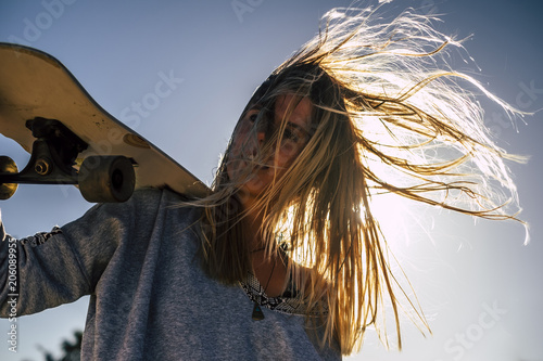 Obraz na plátně long blonde hair moved by the wind in a summer day of vacation for beautiful blonde model with skateboard