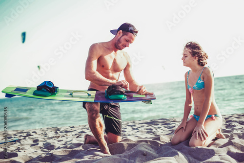 Photography Man instructor teaches the young girl in kite surfing