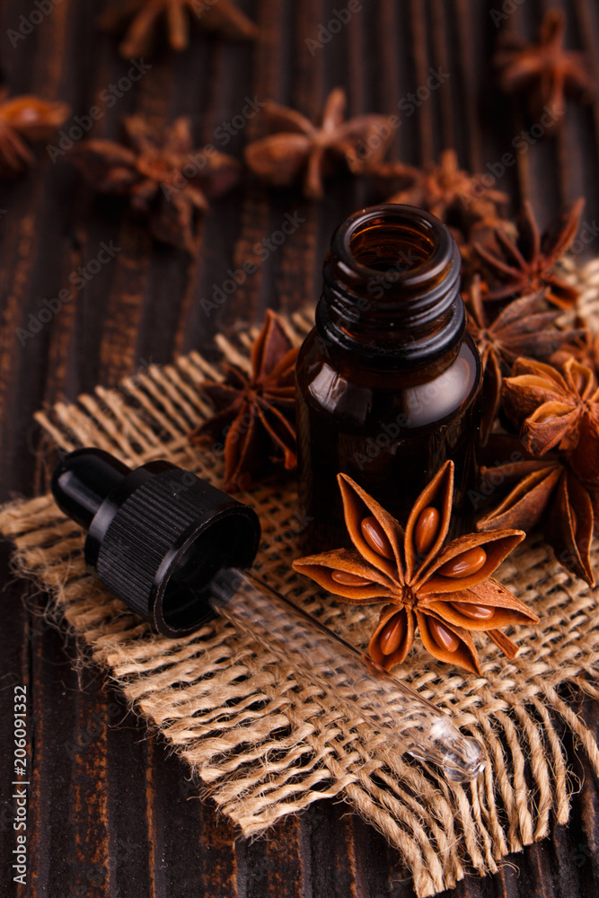 essential oil of the anise stars on a dark rustic background