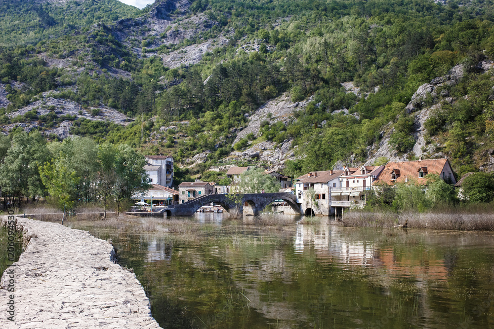 Fototapeta premium asphalt road near the river, green mountains, stone old houses Montenegro