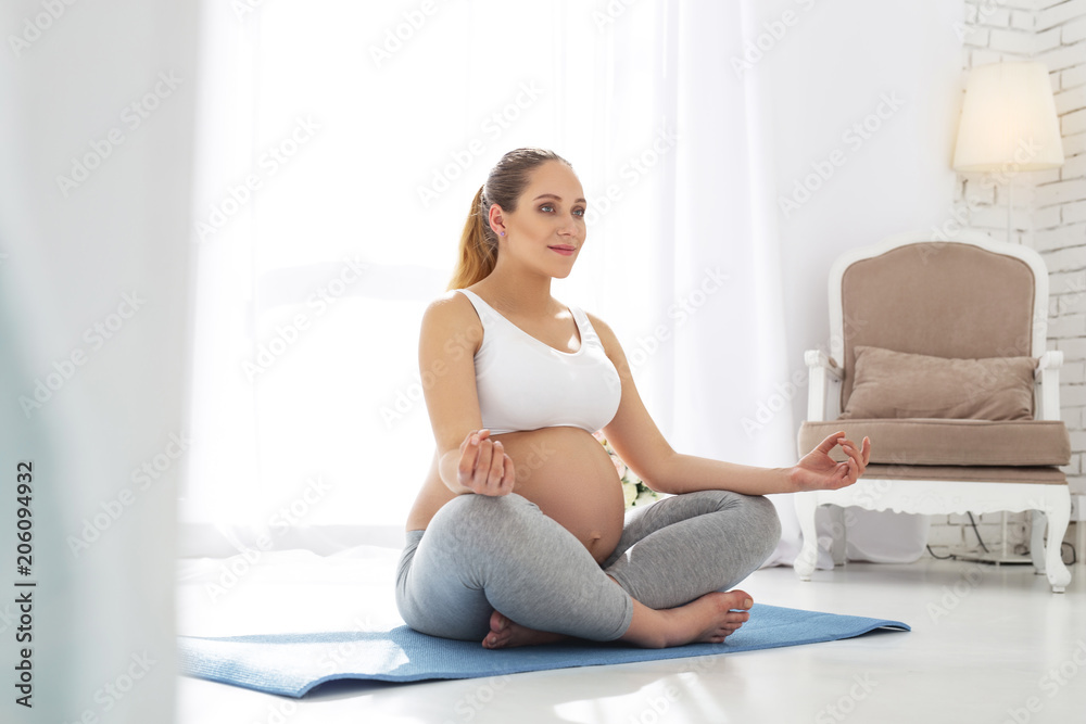 Meditation for pregnant. Positive pregnant woman meditating while looking straight