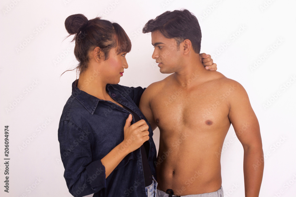 Portrait of young girl and bare chested boy looking at each other Portrait of young girl and bare chested boy looking at each other