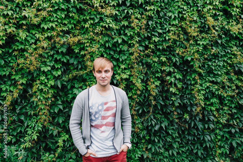 Portrait of a stylish man against a green foliage background. Portrait of a stylish man against a green foliage background.