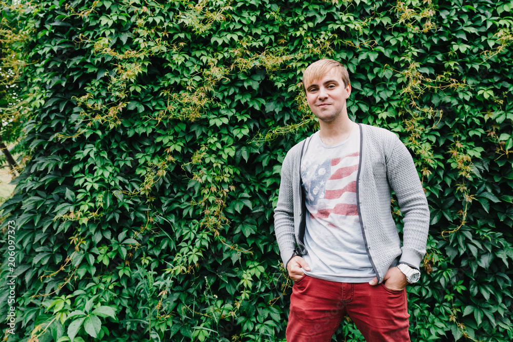 Portrait of a stylish man against a green foliage background. Portrait of a stylish man against a green foliage background.
